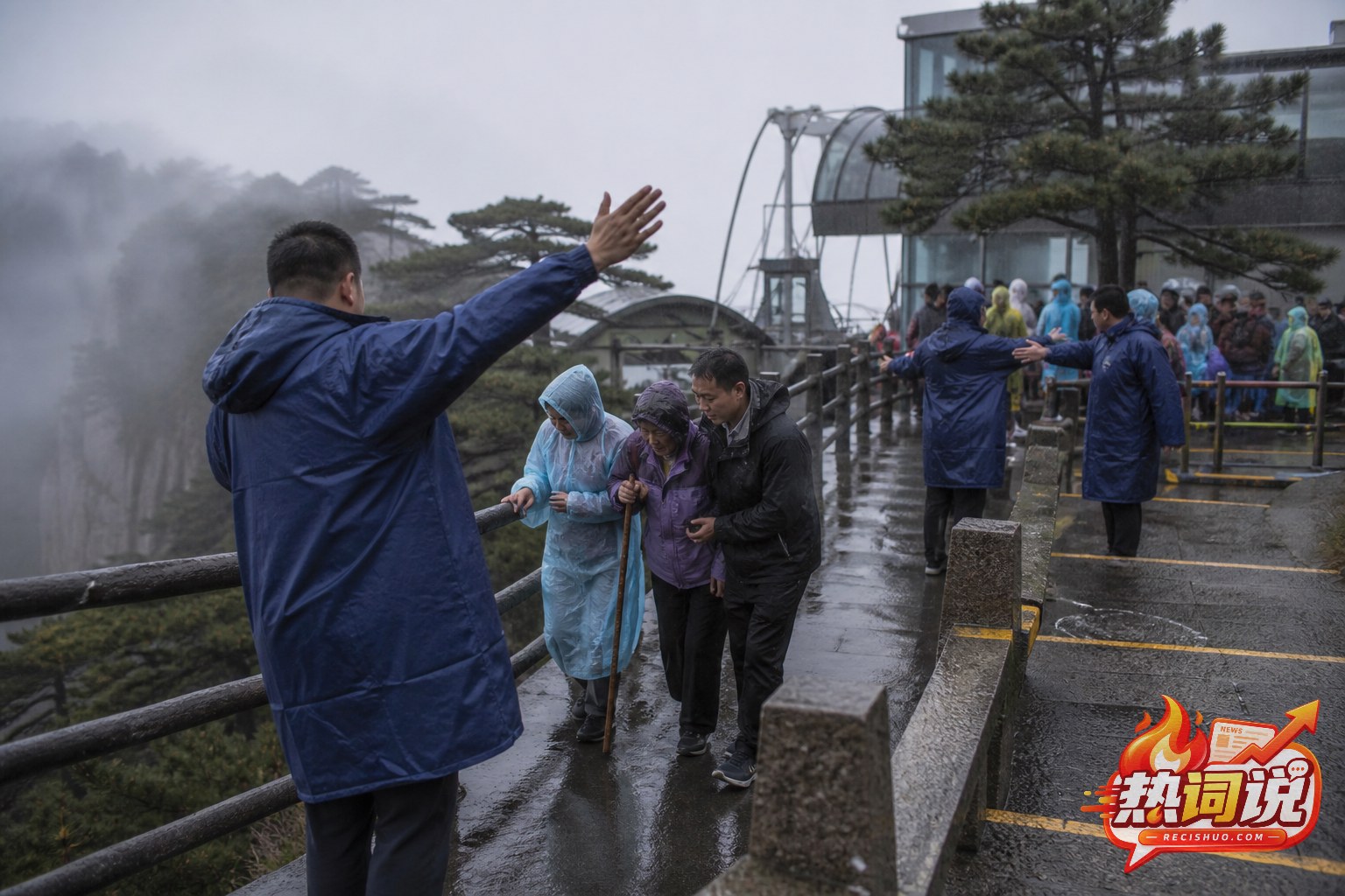 黄山景区工作人员在湿滑步道上引导并协助游客分批转移