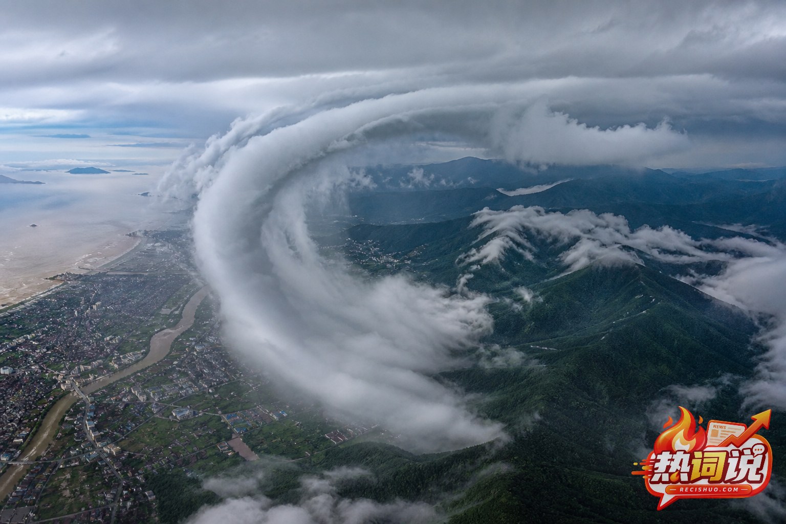 台风雨带以巨大弧形横跨浙江沿海城市与浙南山地的高空纪实画面