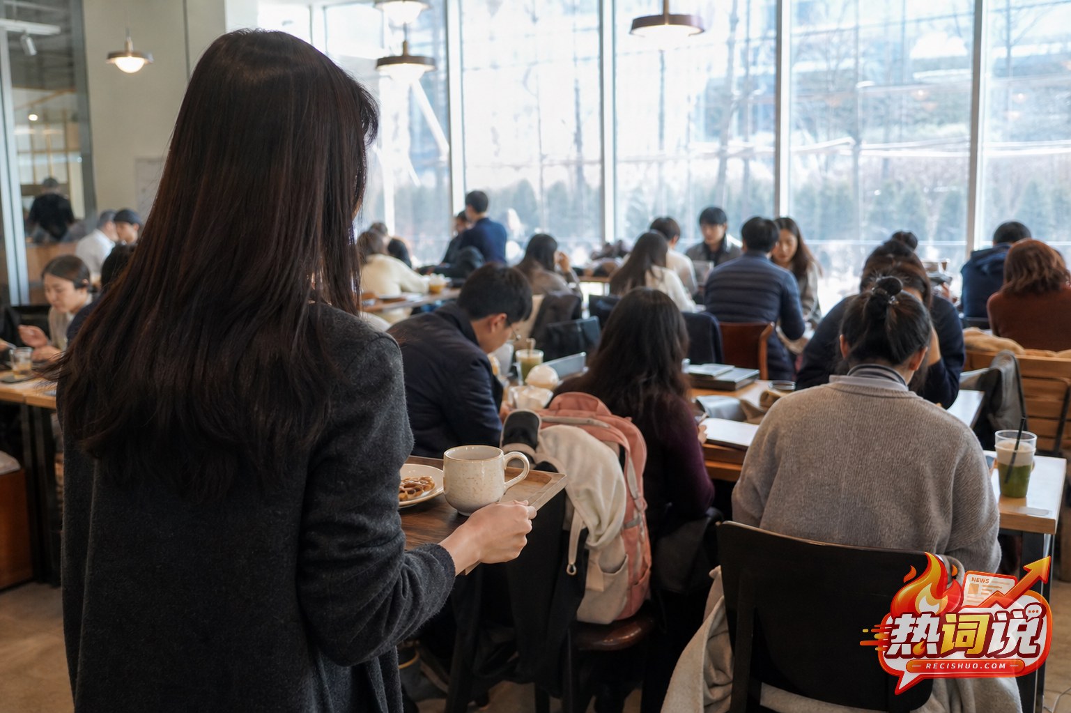午间咖啡店座位紧张,端着饮品和点心的顾客正在寻找空位