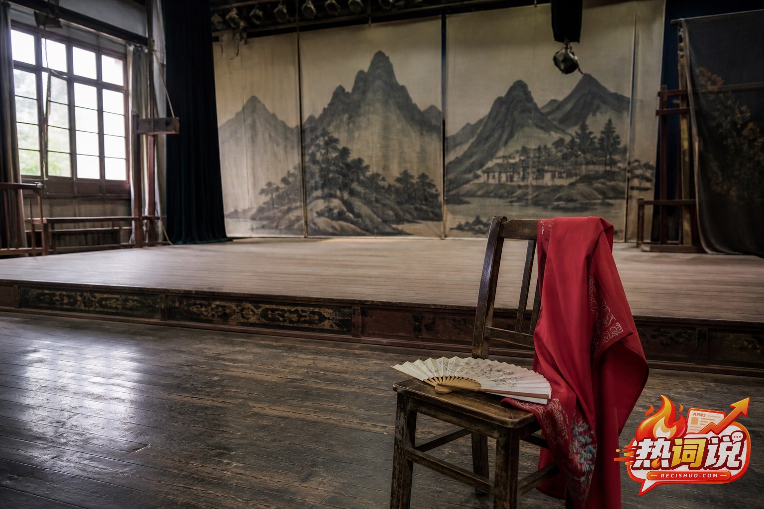 老剧场排练舞台上的木椅、折扇和红色戏服,呈现民族歌剧的表演传统