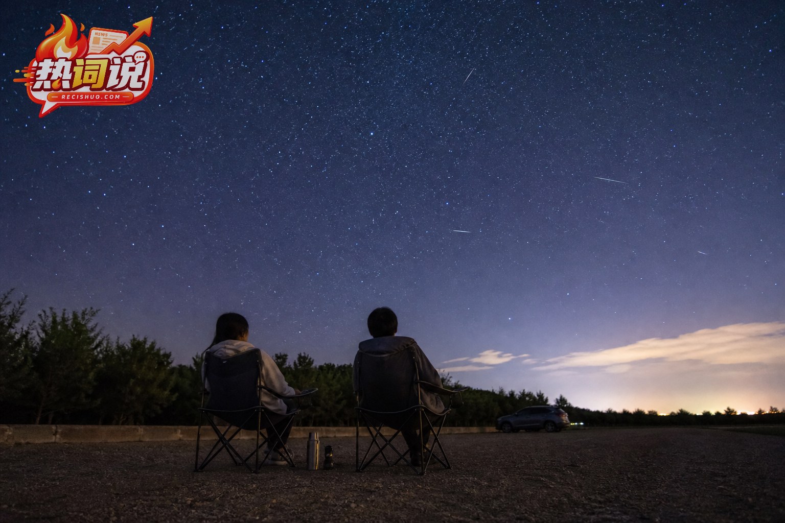 两名观星者坐在安全开阔的郊外场地观看流星雨