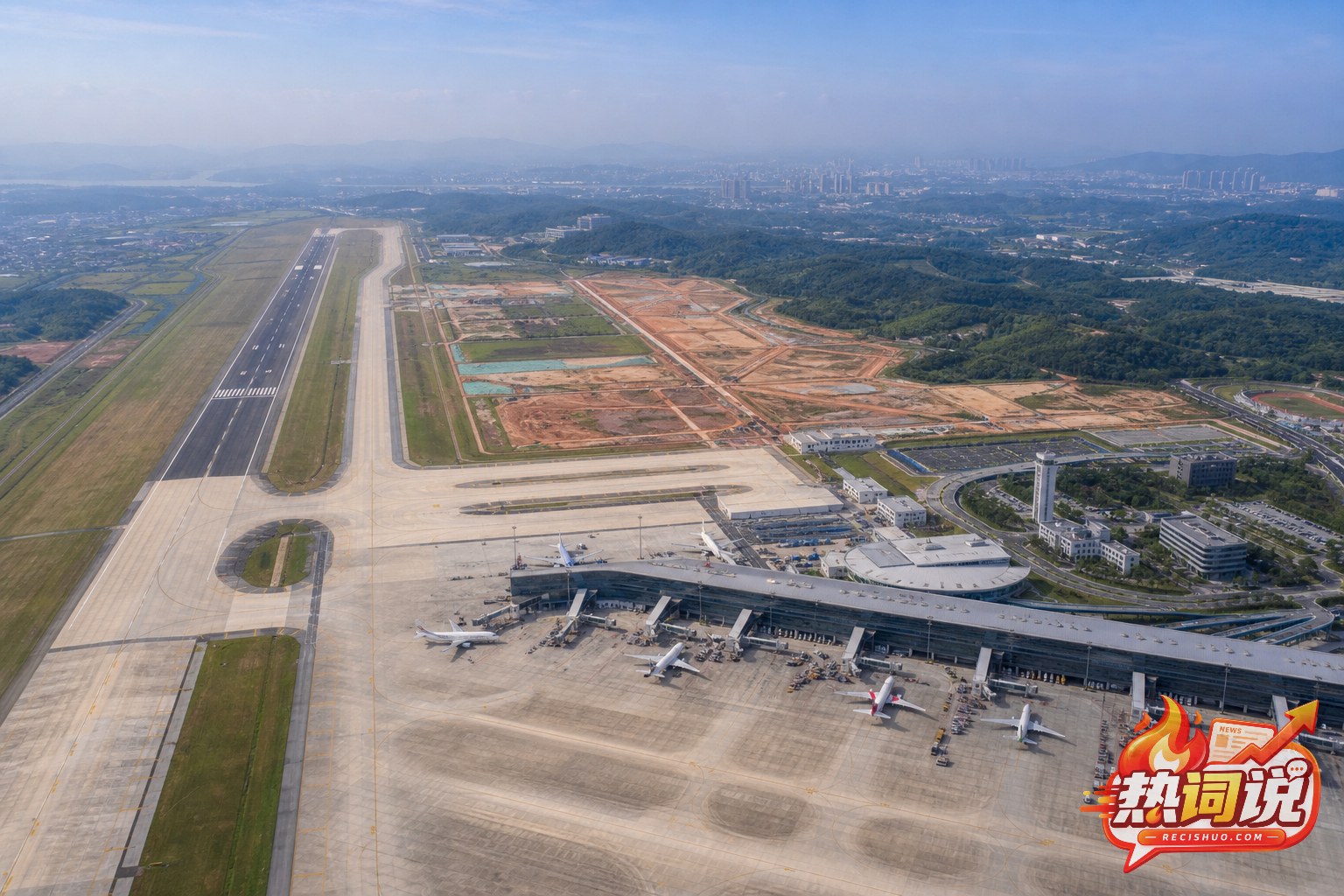 现代化机场航站楼、跑道与扩建预留区域的航拍画面