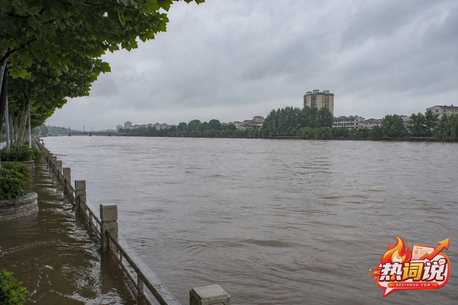 阴云下河南城市河道水位上涨并接近岸边栏杆的全景