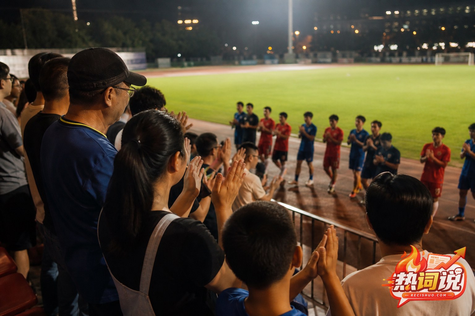 夜场城市足球赛后球迷在看台前为双方球员鼓掌