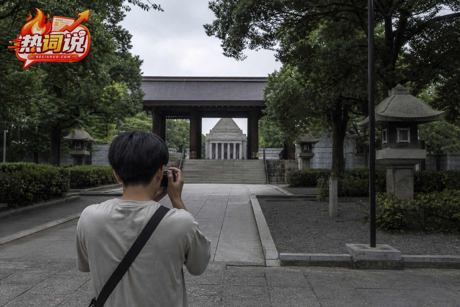 一名年轻拍摄者在阴天的日式纪念建筑公共区域进行现场记录