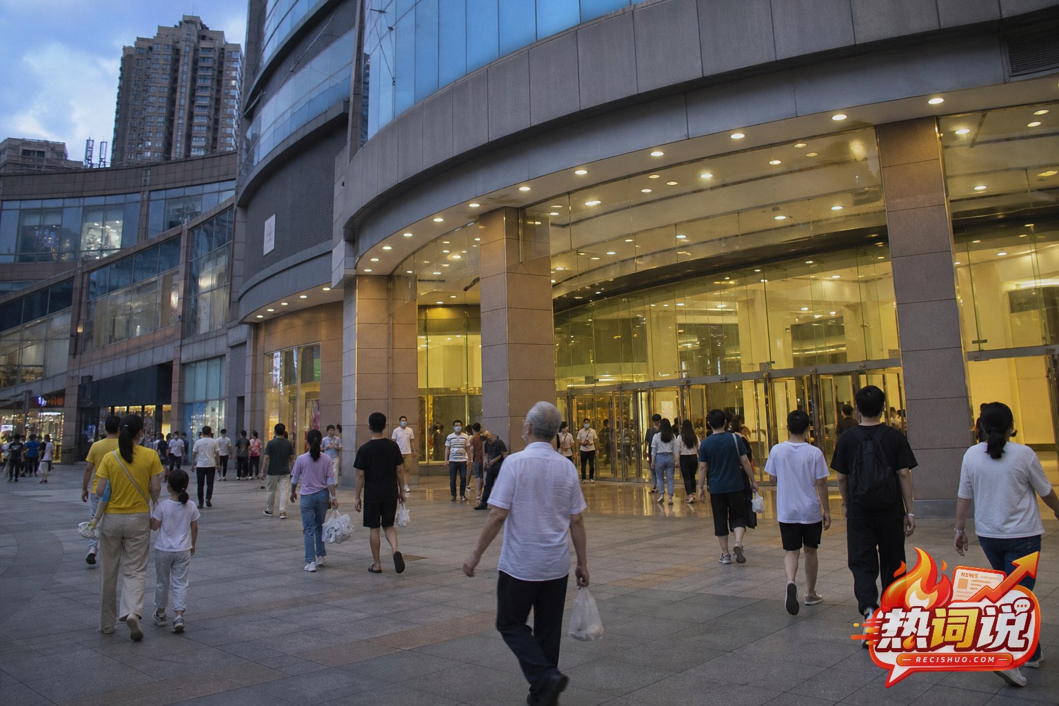傍晚顾客走进城市大型商业综合体的纪实场景