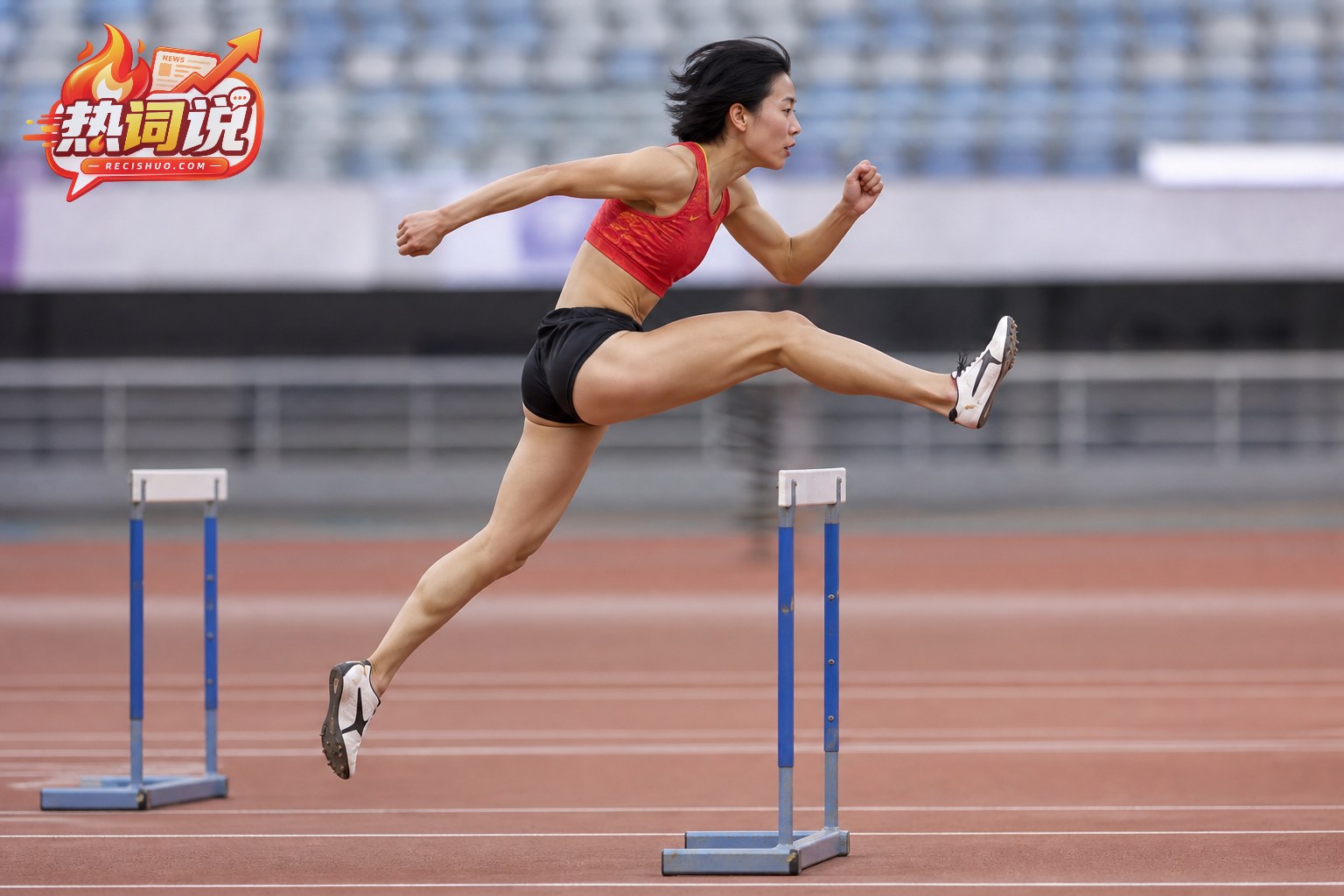 女子跨栏运动员从侧面越过栏架并保持栏间节奏