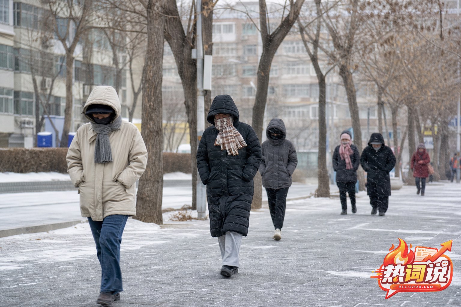 寒潮天气中穿着厚外套行走在城市街头的市民