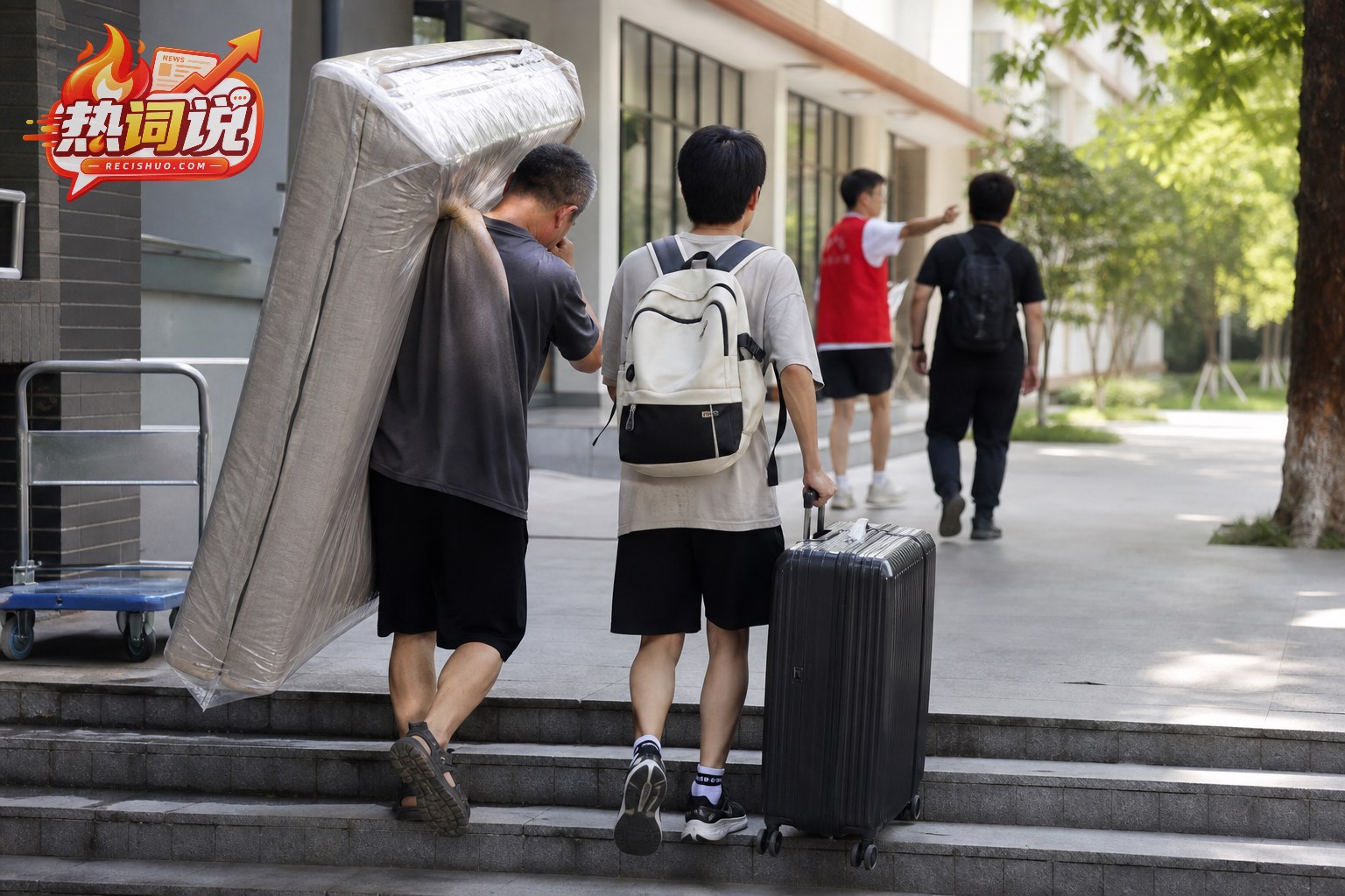 宿舍楼入口处,父亲扛着包装床垫与拉行李箱的新生共同上台阶