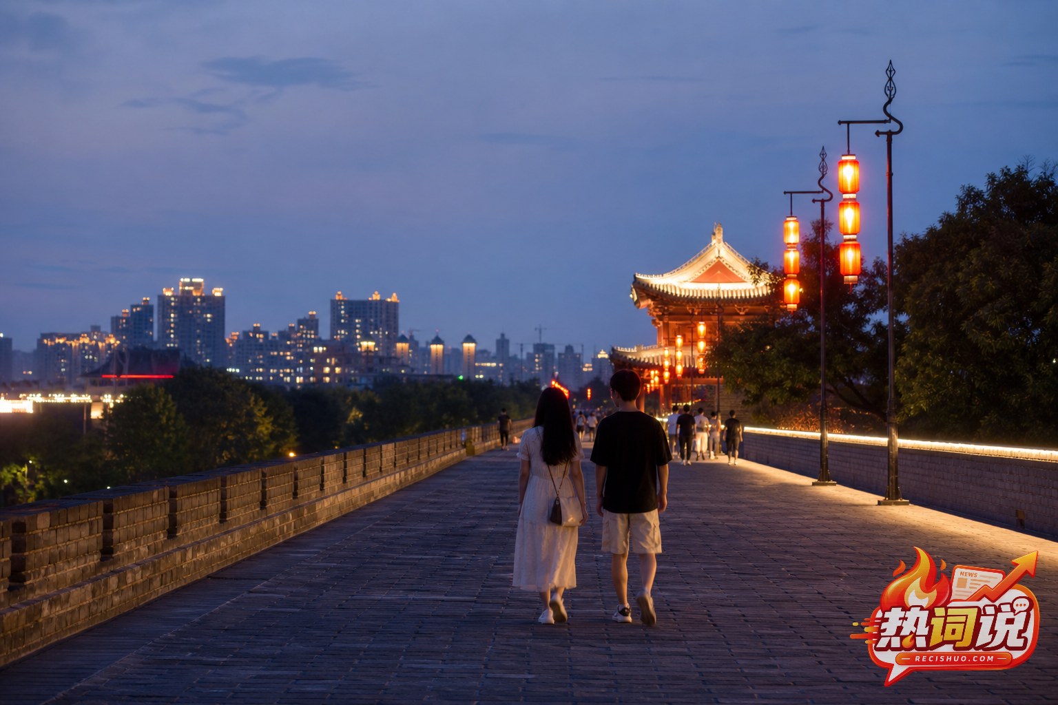 七夕傍晚两名游客并肩走在亮灯的古城墙步道上