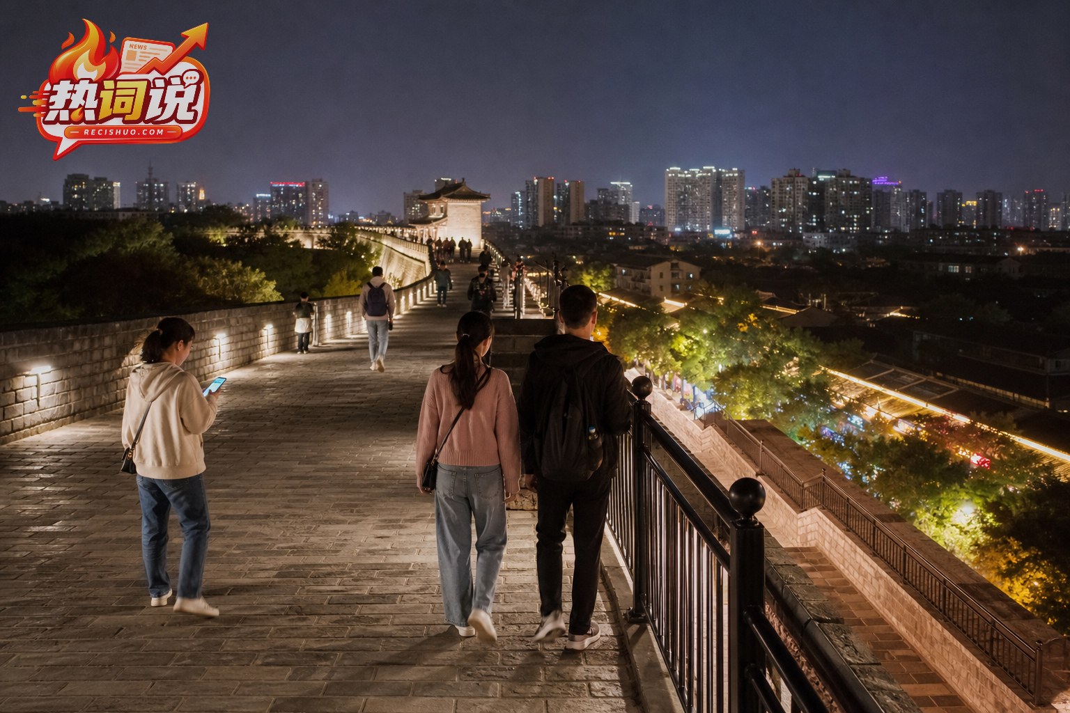 游客夜间沿设有护栏的城墙步道观景行走