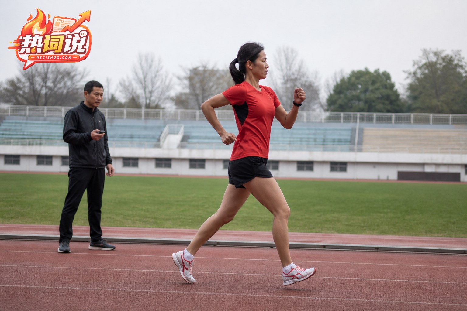 女子竞走运动员在教练计时观察下进行跑道训练