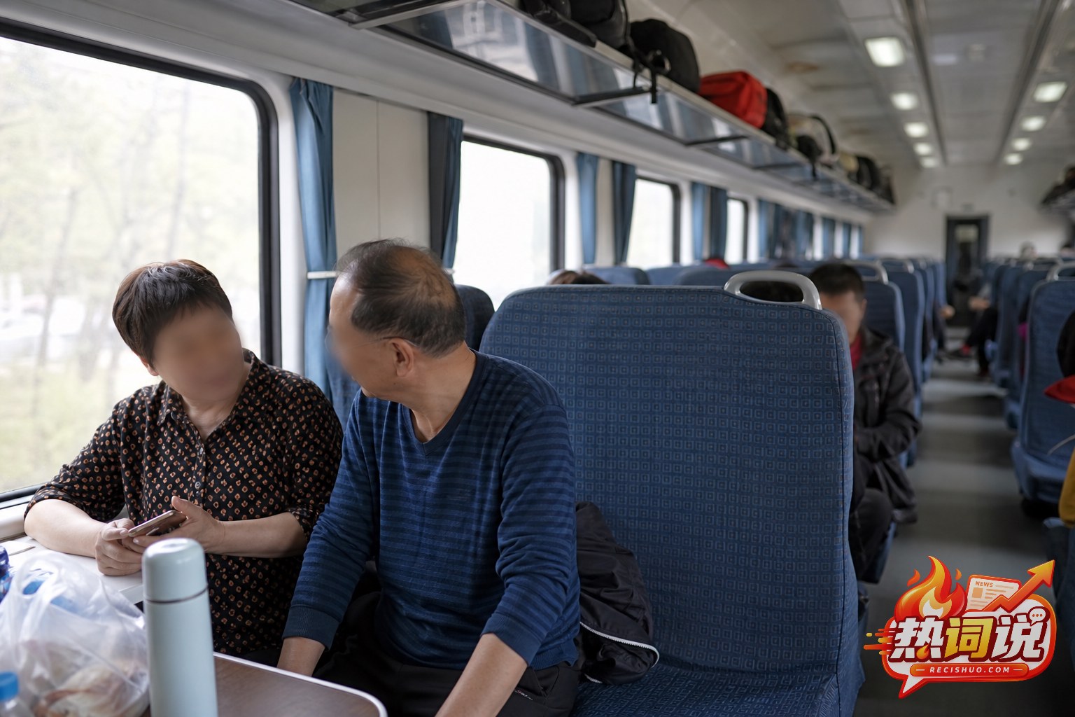 普通长途列车硬座车厢内两名旅客就座、相邻席位空置的场景