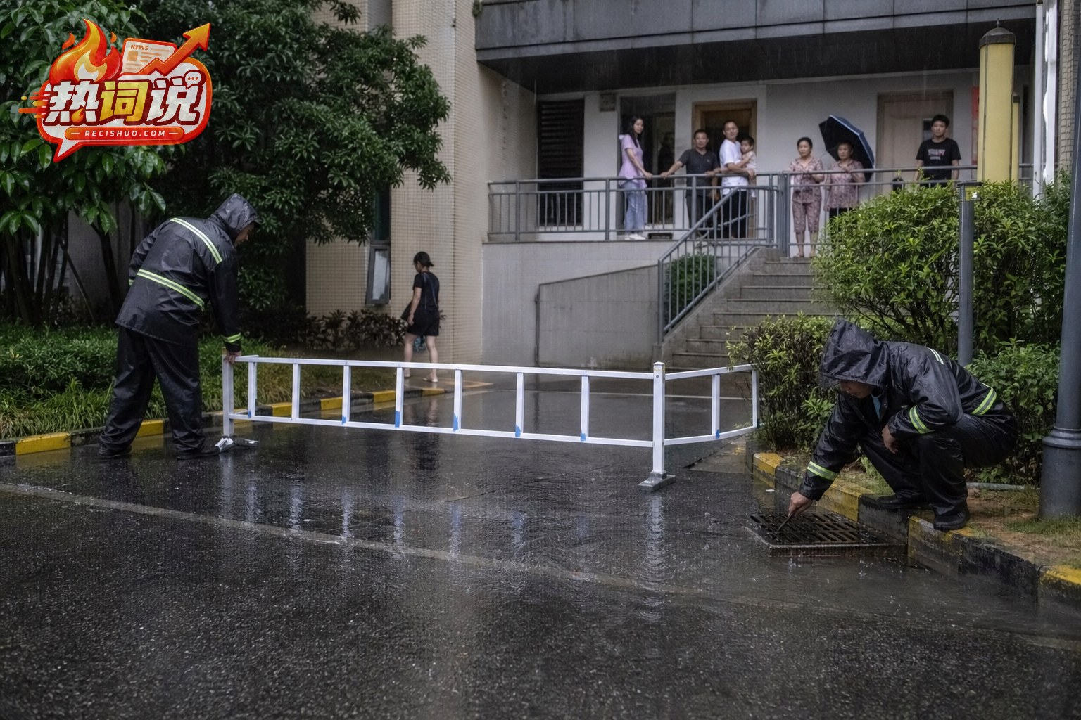持续降雨中小区工作人员检查排水口并设置隔离设施