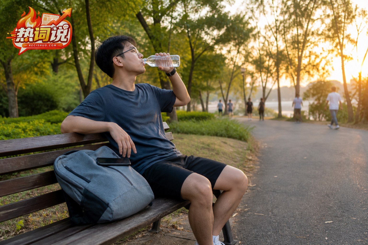 年轻人在夏末傍晚散步后坐在公园长椅上喝水休息