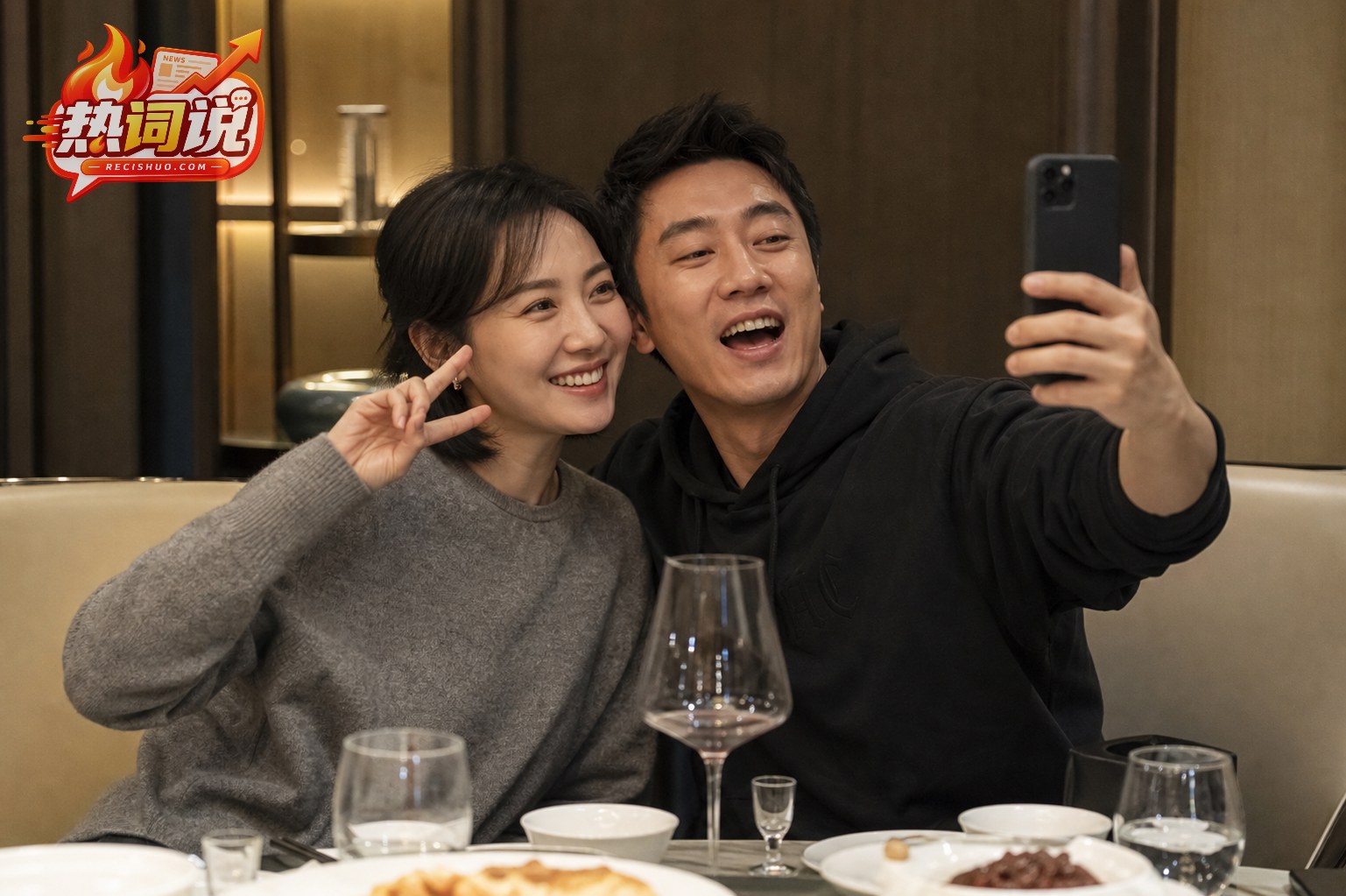两位老友在温馨餐厅聚会并用手机开心合影的编辑配图