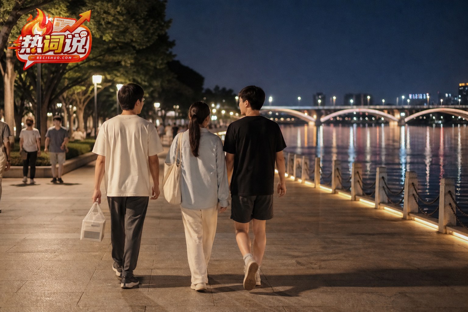 三位朋友吃完夜宵后沿灯光明亮的城市滨河步道散步