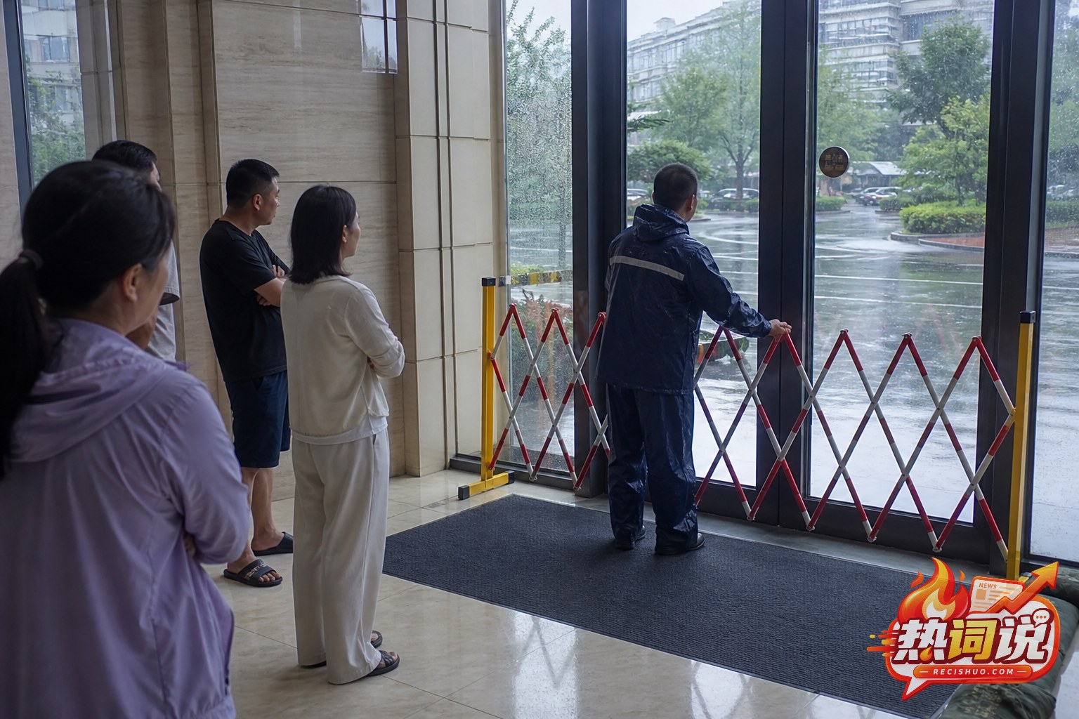 台风暴雨期间居民留在建筑门厅内并听从物业安全管控