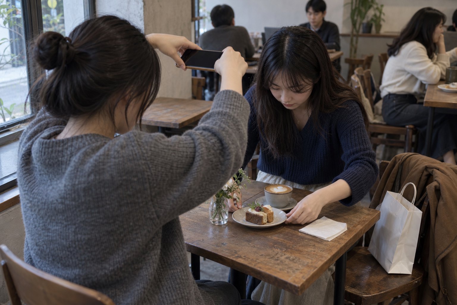两名年轻人在咖啡馆为精心摆放的餐点拍照