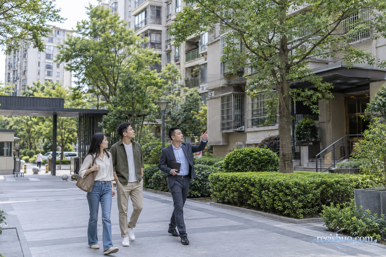 购房者在经纪人陪同下实地查看成熟住宅社区环境
