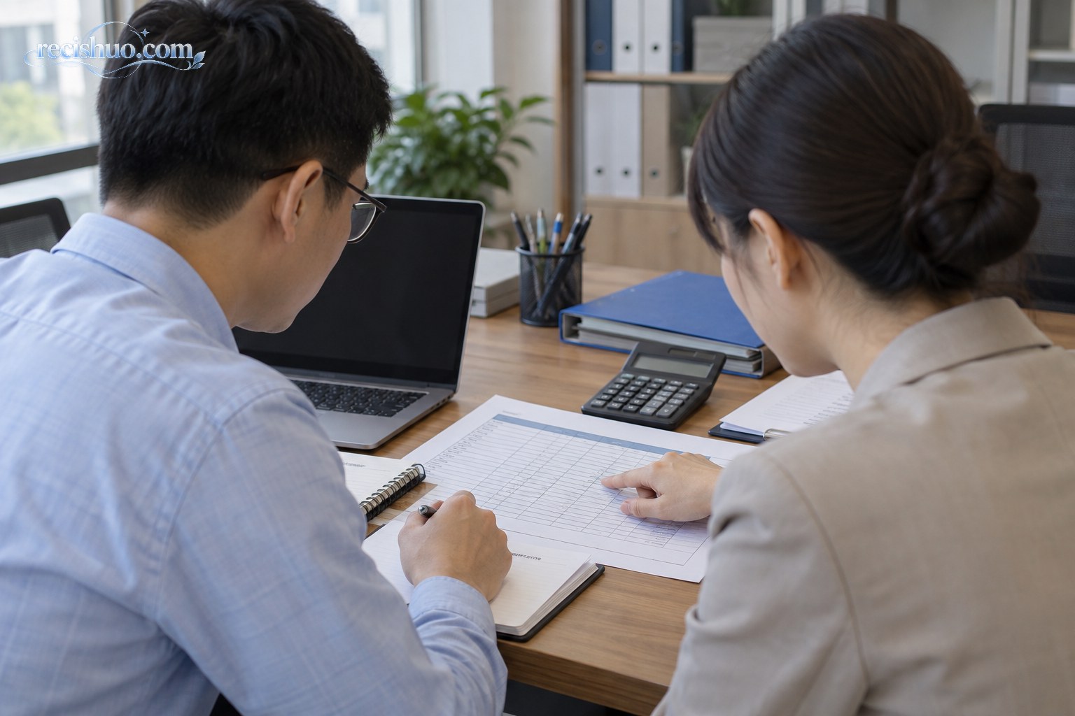 企业人事工作人员共同核对员工缴费基数表格
