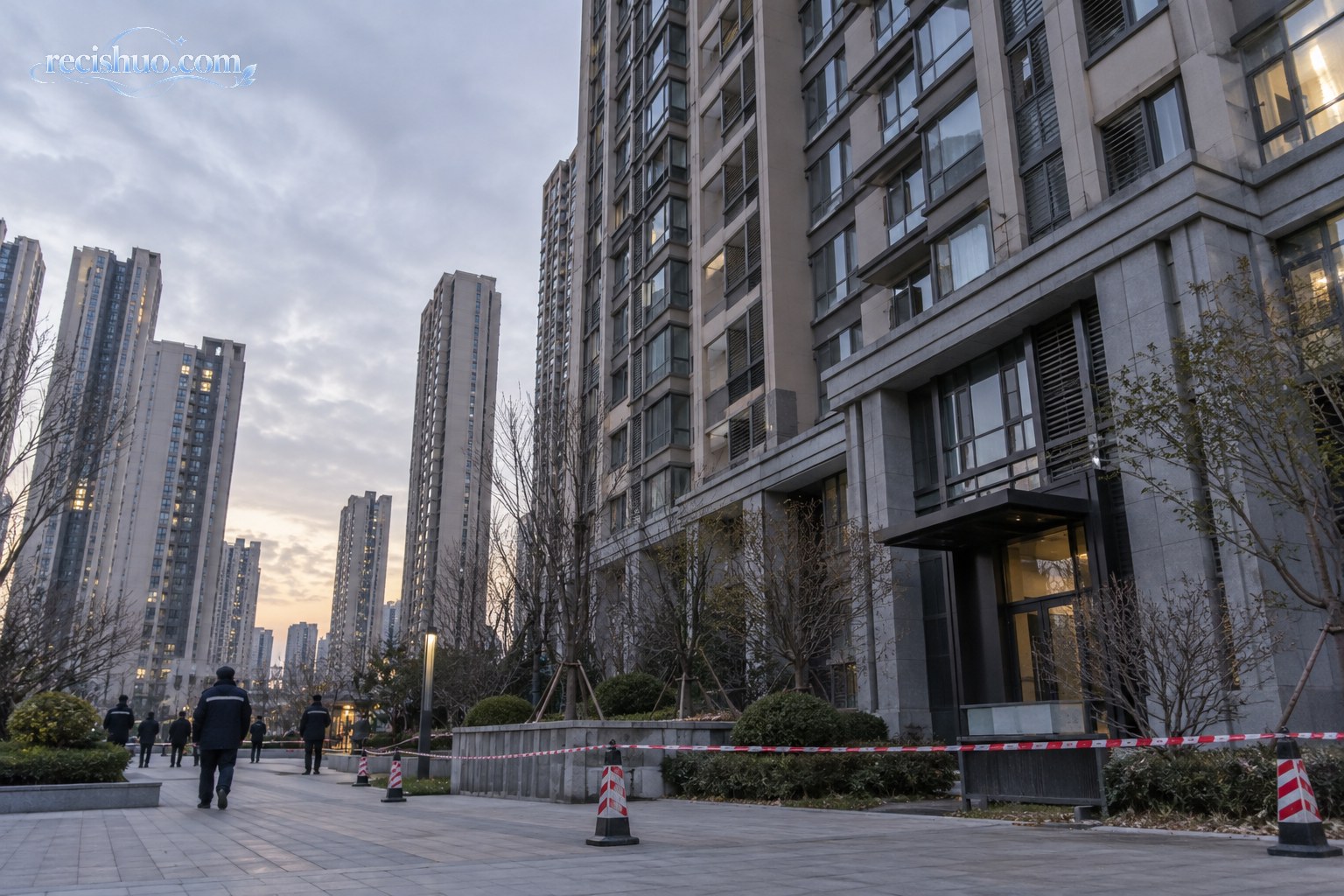 阴天傍晚的城市高层住宅楼下设置安全隔离带,巡查人员从公共通道经过