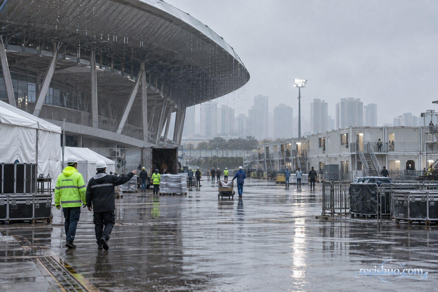 阴雨天气下工作人员检查体育场与模块化临时住宿区