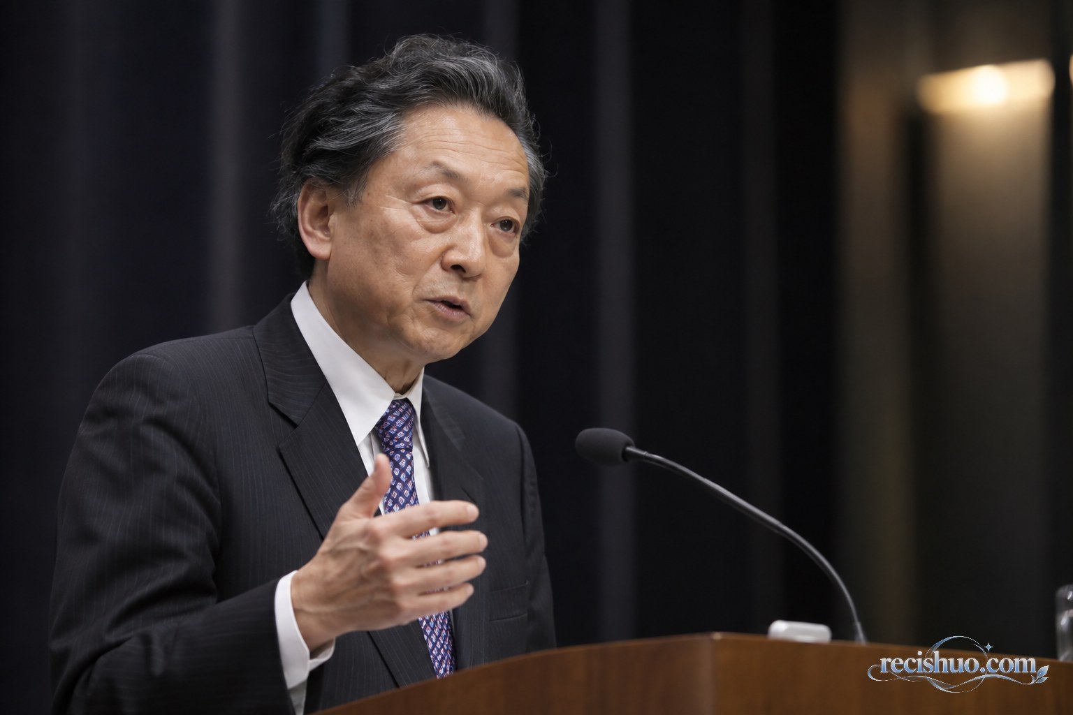 鸠山由纪夫在庄重的室内讲台前发言