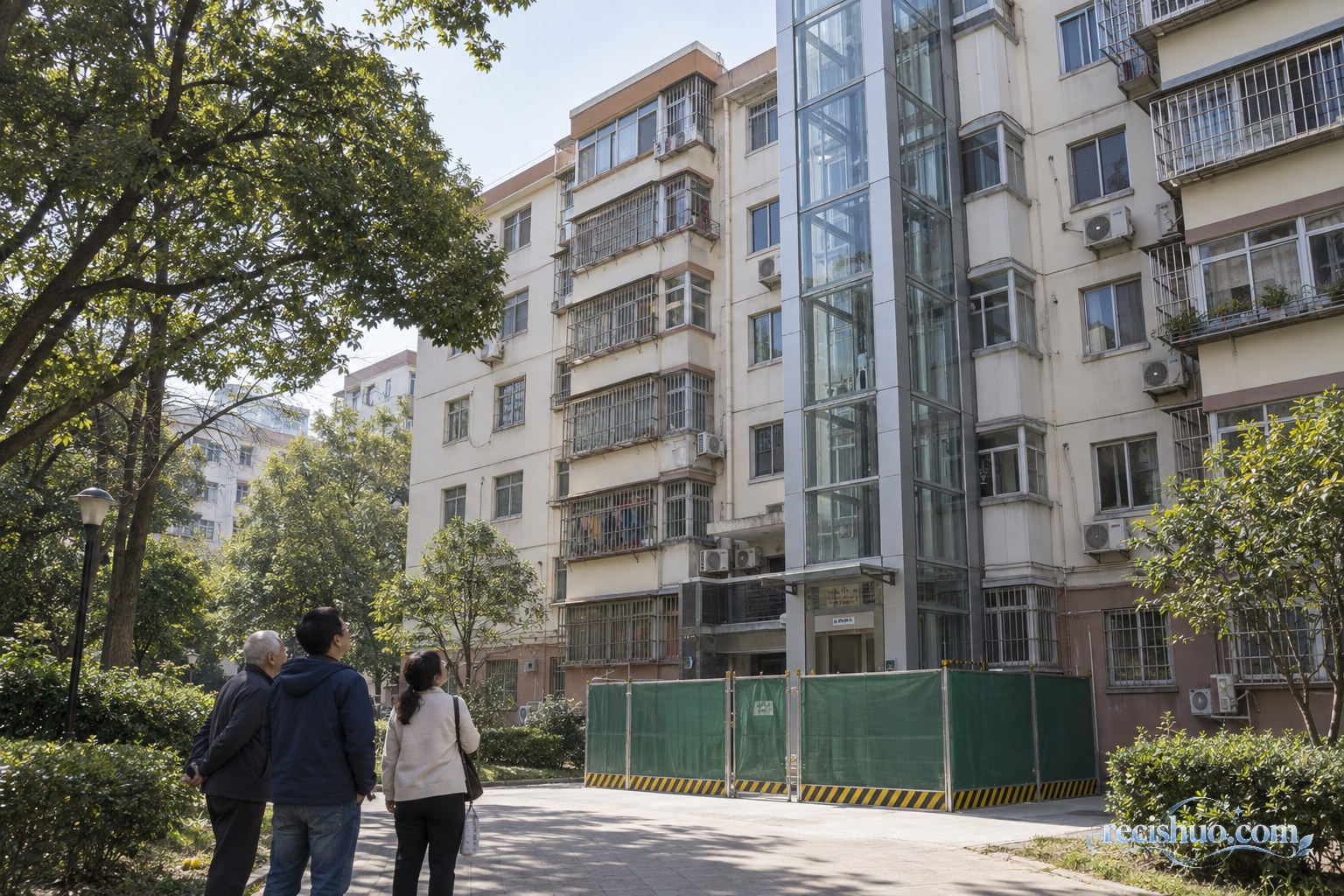 城市既有多层住宅楼外侧加装玻璃电梯,居民在安全围挡外查看施工情况