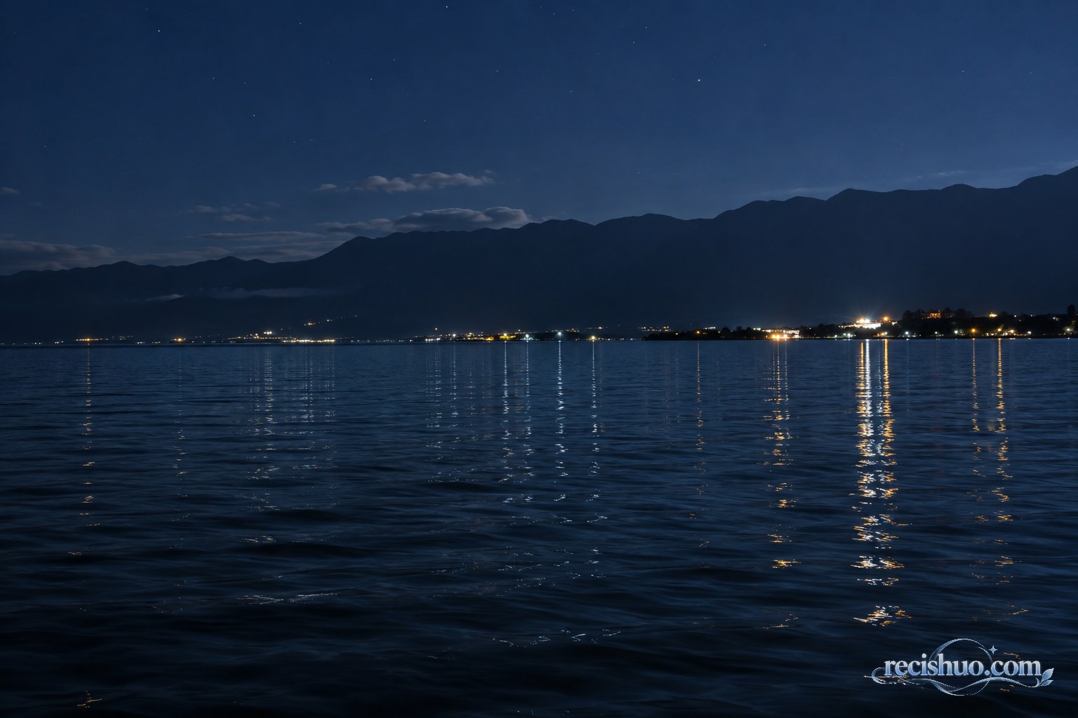 洱海夜色中远岸灯光随水波形成银蓝色与暖色倒影