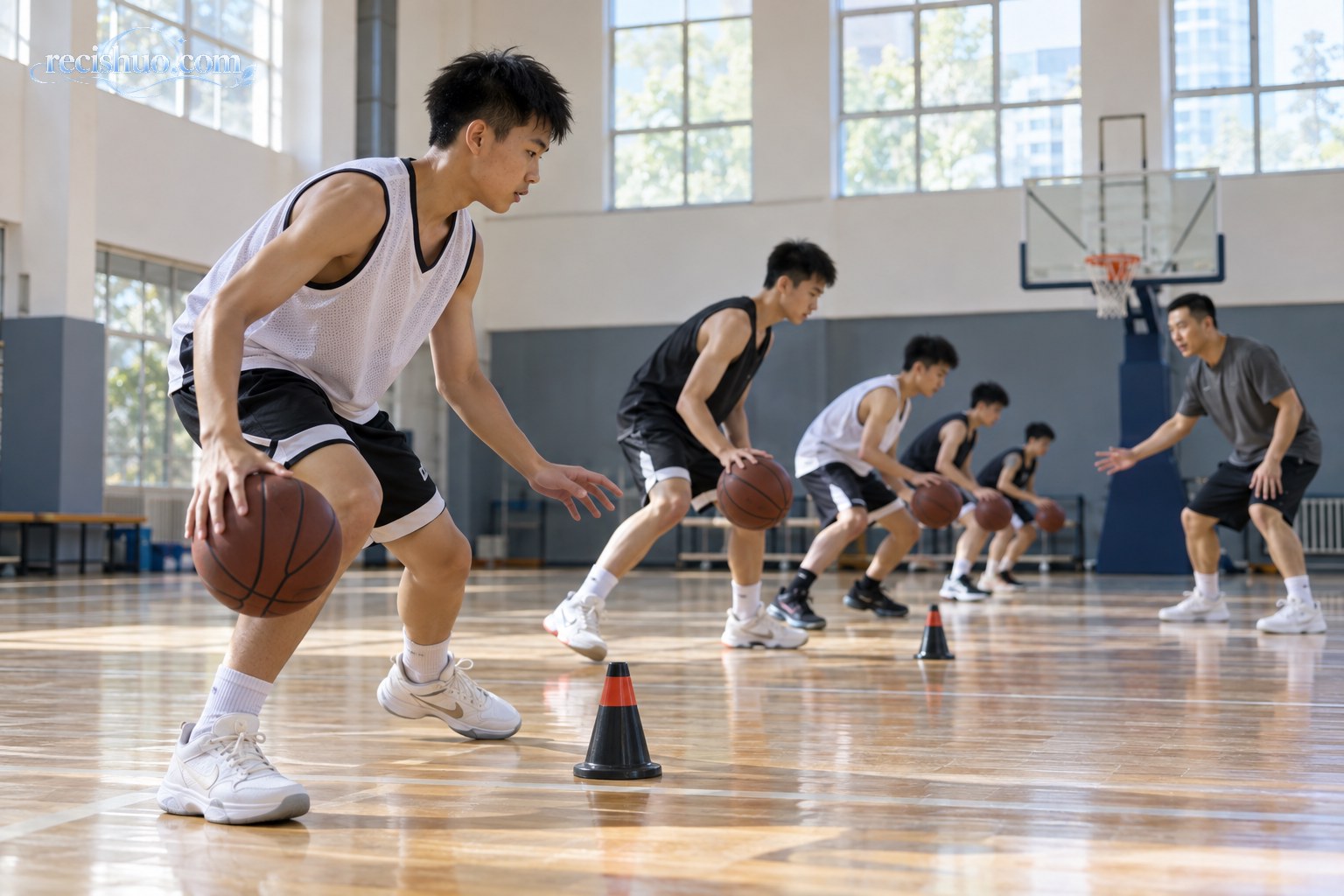 青少年球员在室内篮球馆进行运球与脚步基本功训练