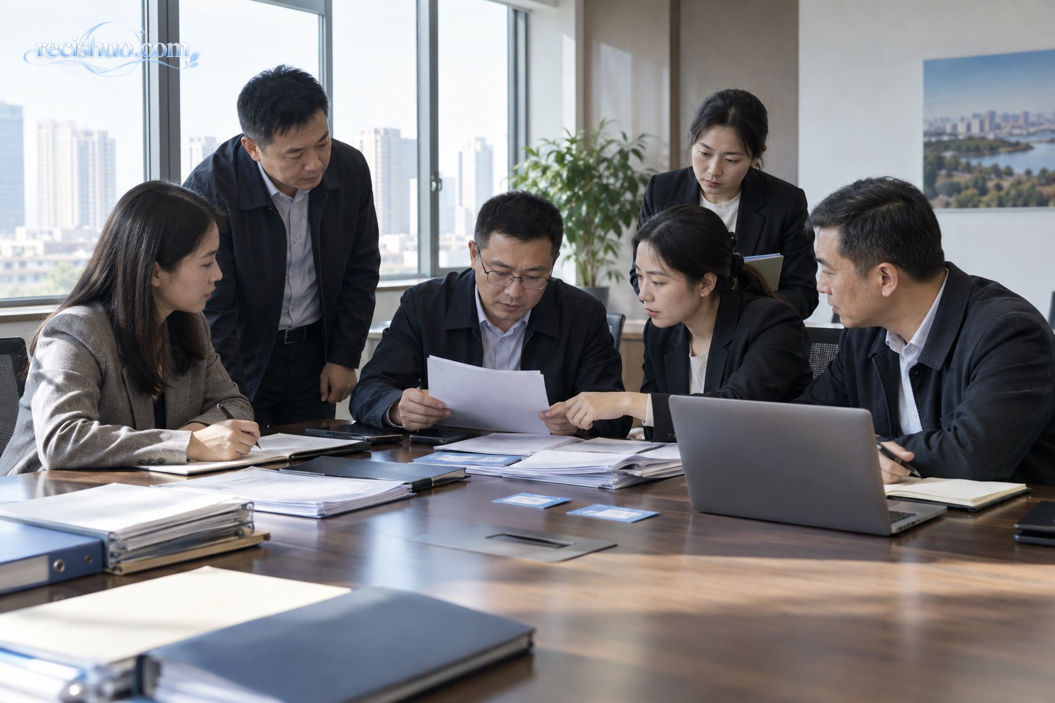 多名工作人员在会议室共同核对社保参保相关材料