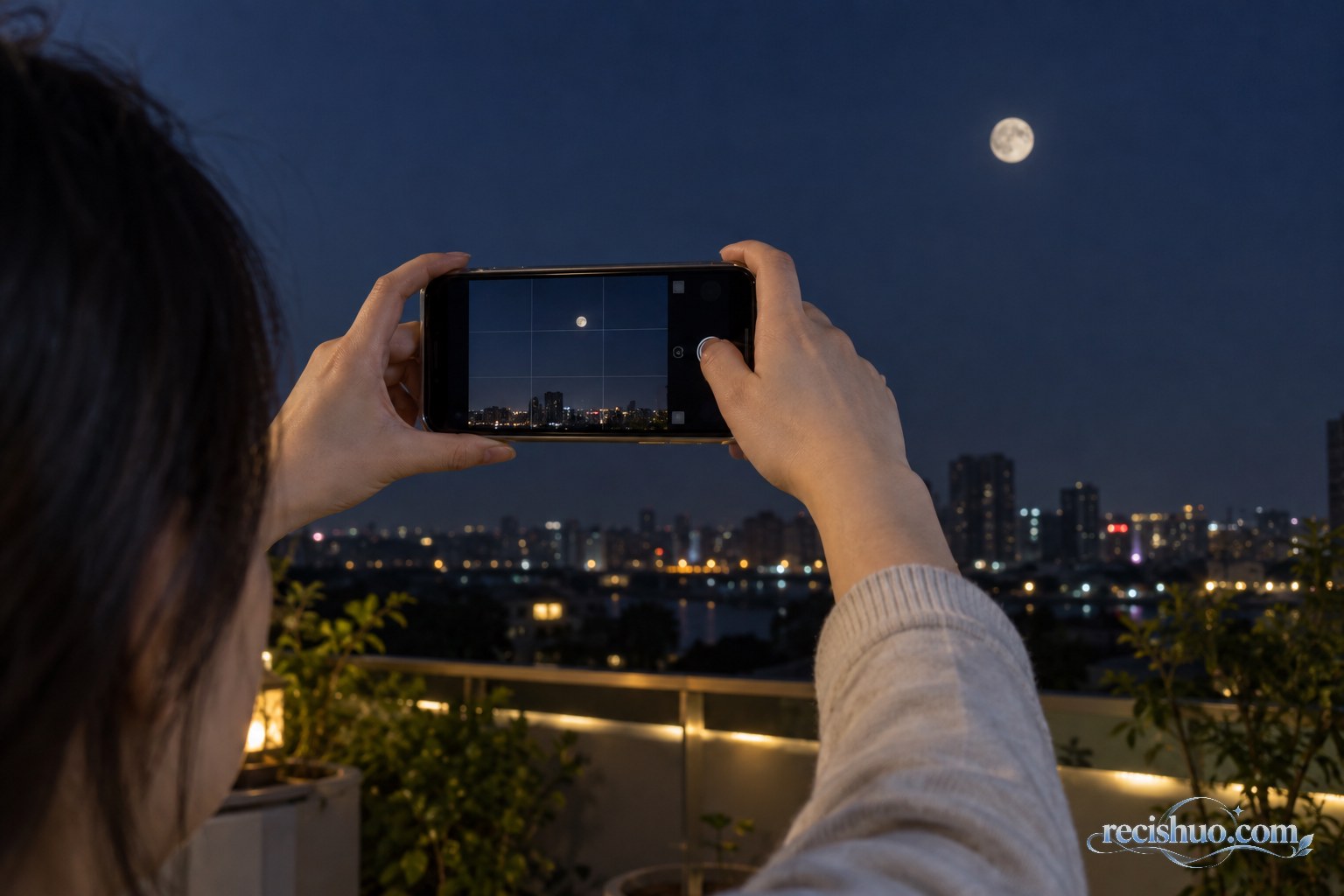 夜晚用手机拍摄城市上空月亮的近景