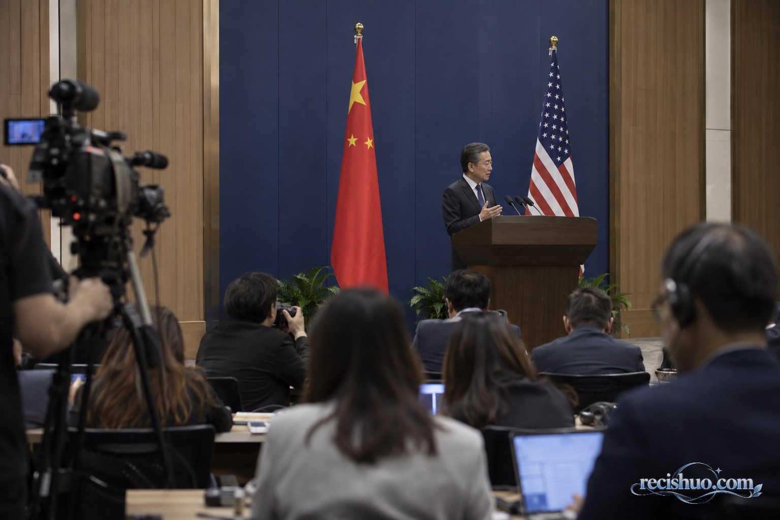 外交情况介绍会现场,记者在中美两国国旗前记录发言