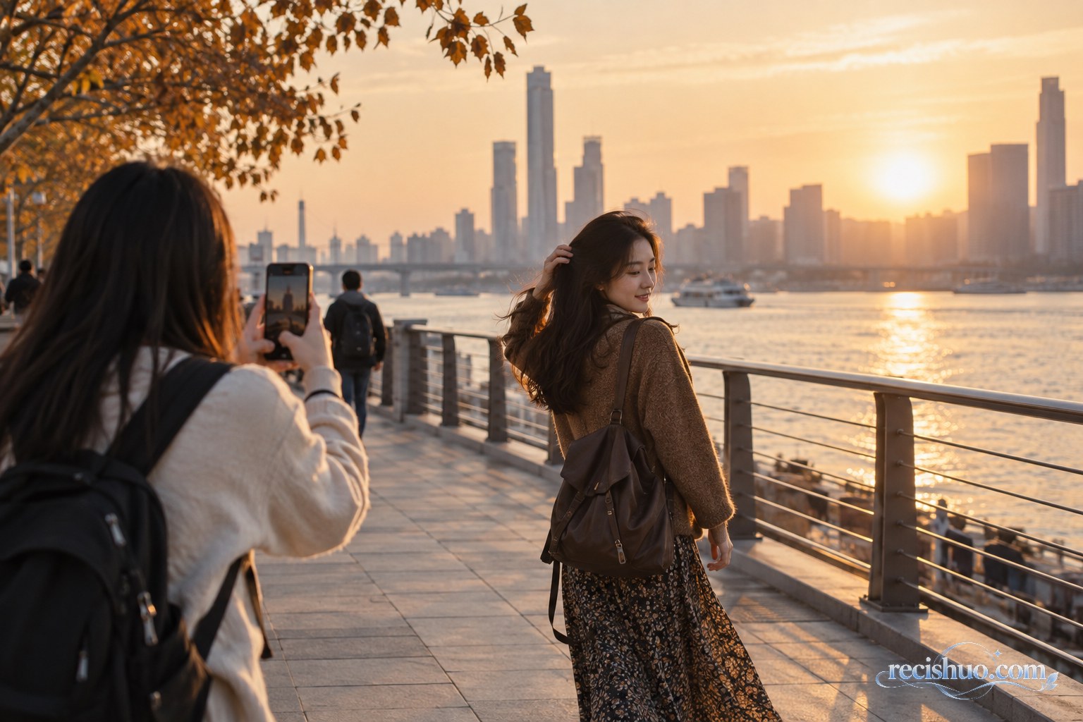 夕阳时分,游客在滨水步道为自然回头的同行者抓拍照片