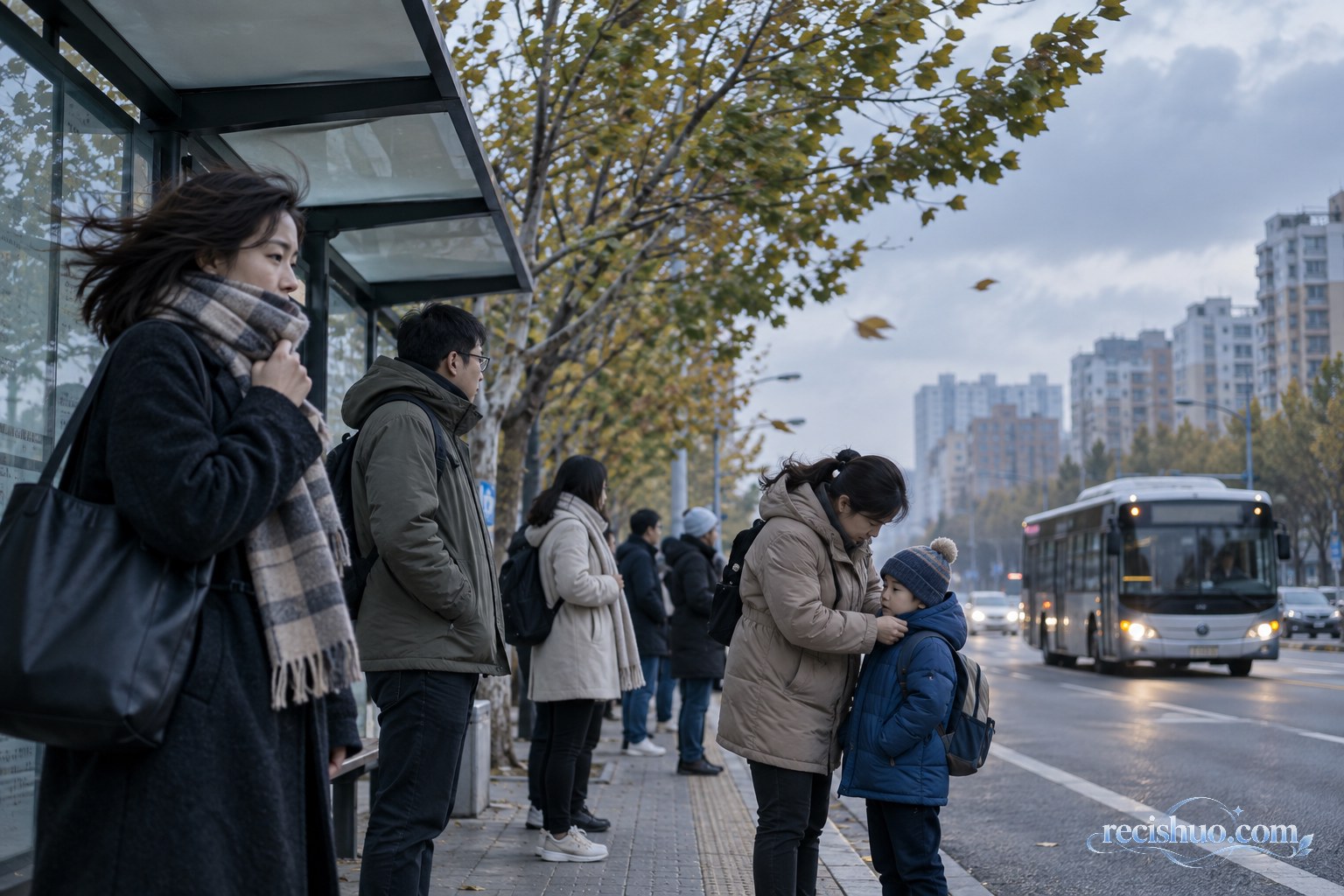 冷空气影响下的清晨公交站,家长为孩子整理防风衣物