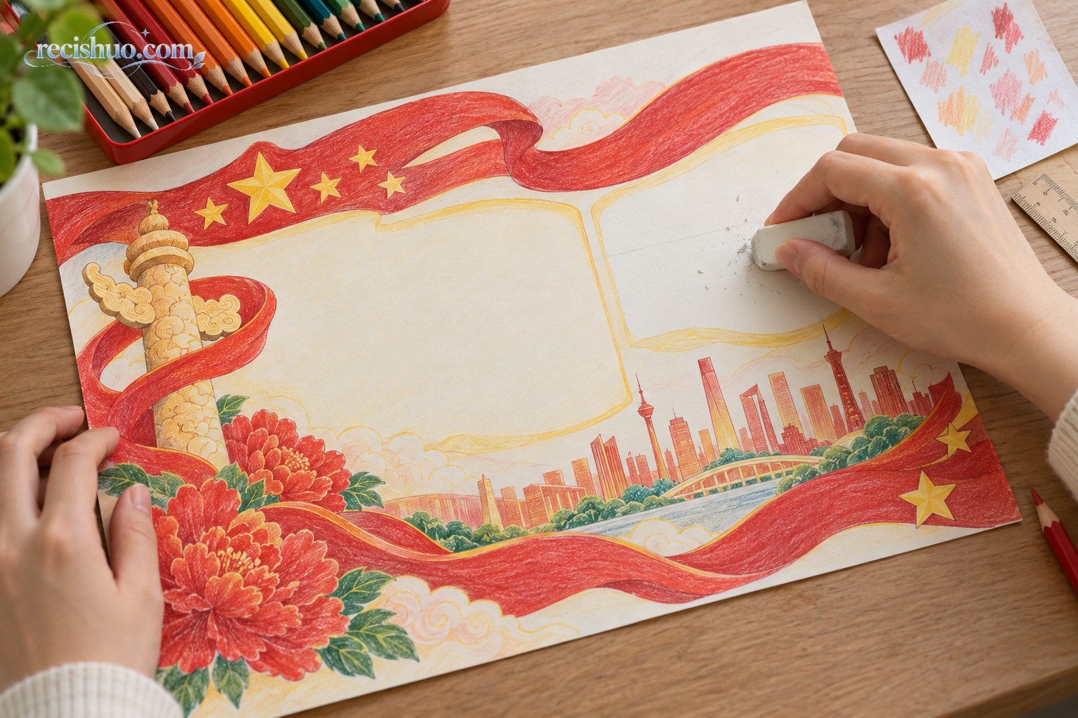 双手为完成的国庆主题手抄报擦除铅笔辅助线