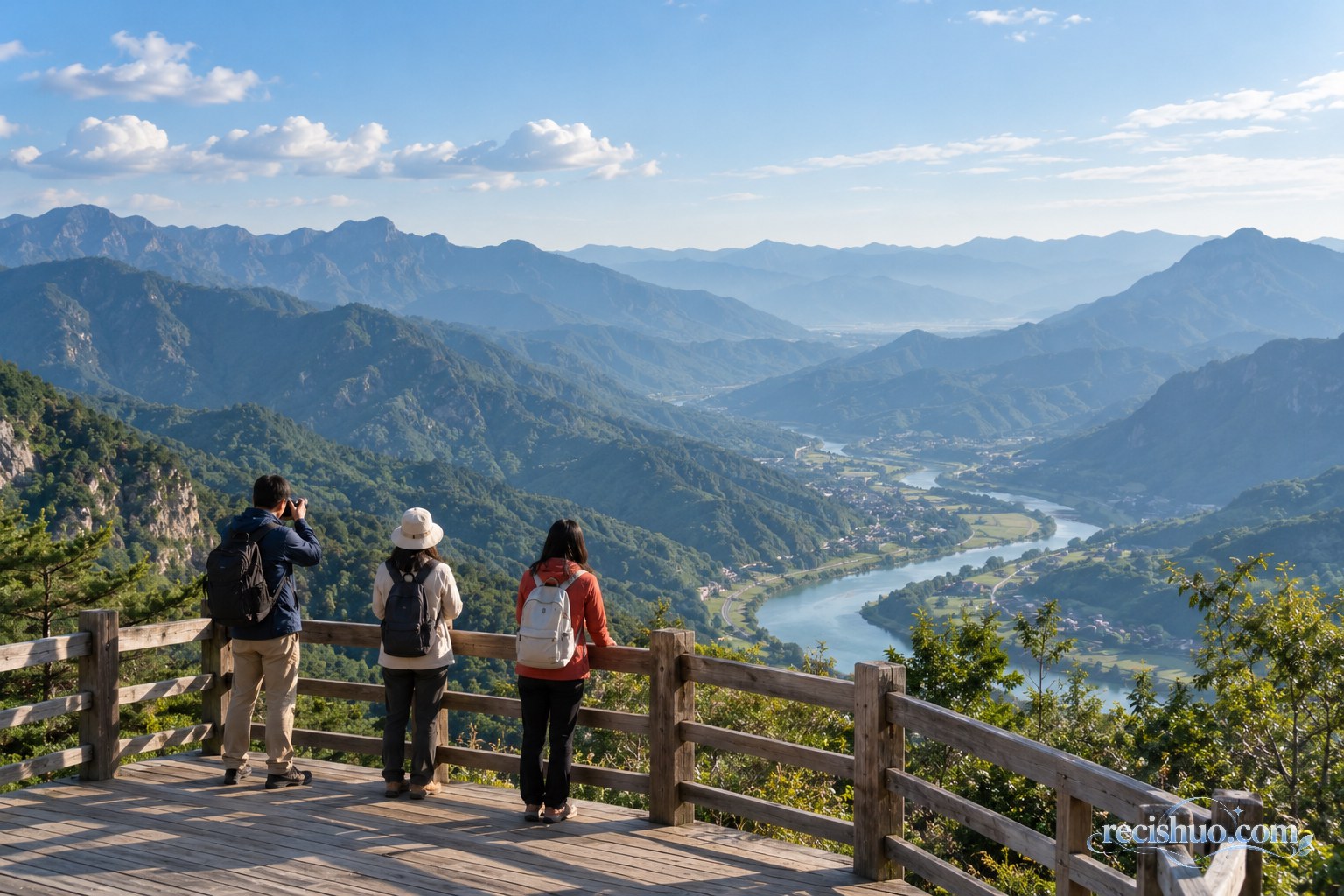 游客站在安全观景台远眺青山河谷并用相机记录风景