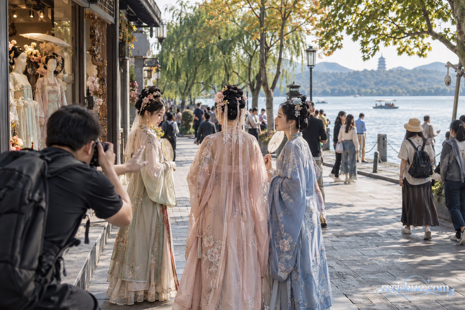 游客身着传统风格服装在西湖边拍照，摄影师与同行者协助完成取景