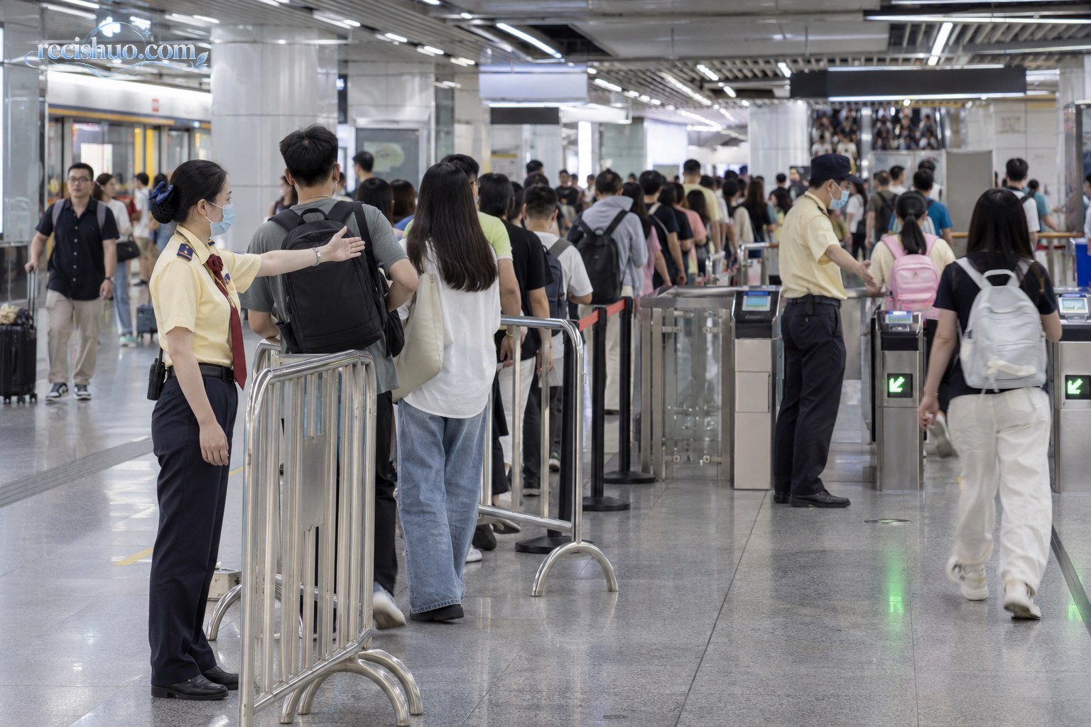 假日客流高峰期间,地铁站工作人员在站厅引导乘客有序排队