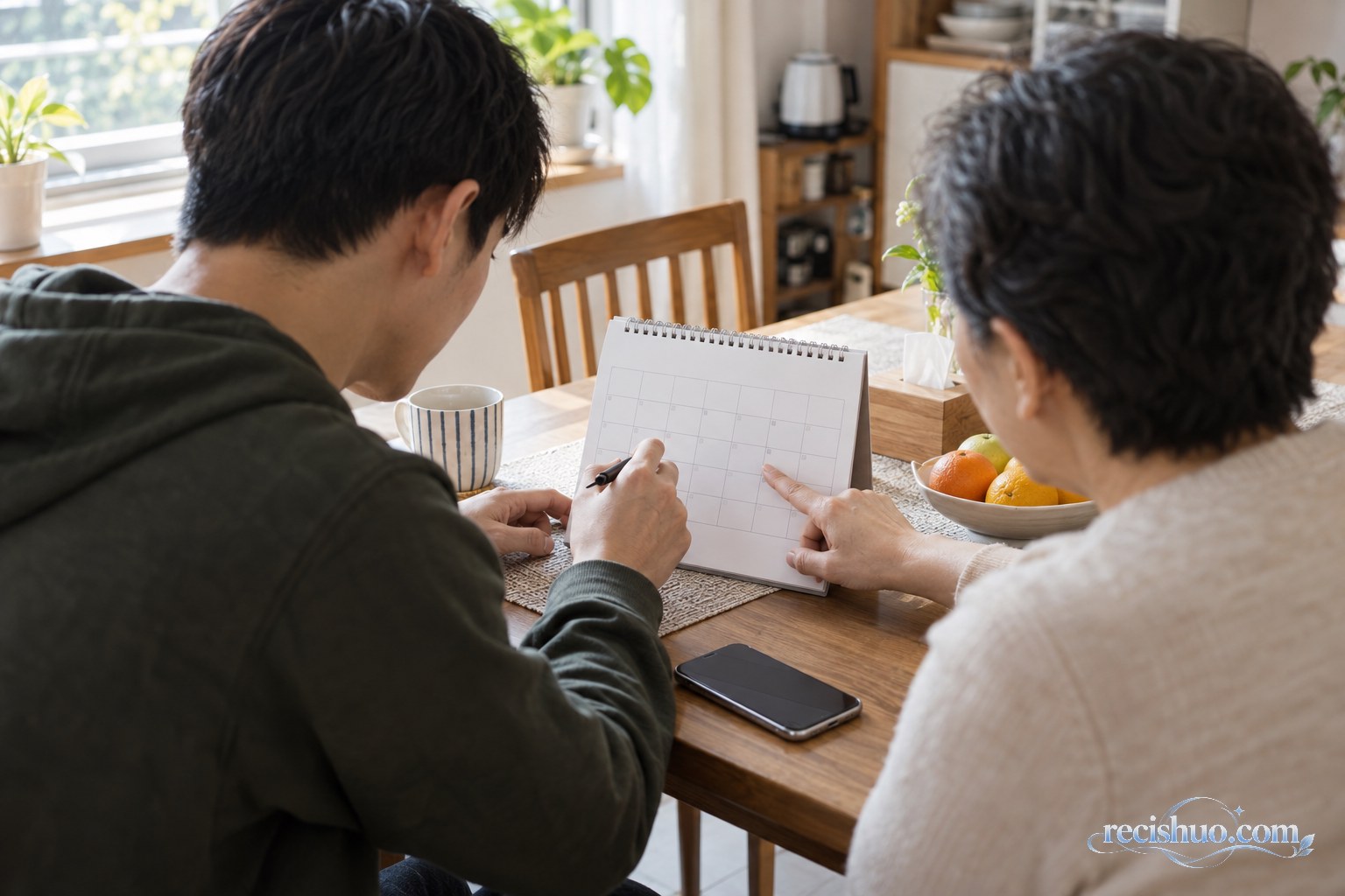 年轻人与家人在餐桌旁查看月历并商量下一次见面时间