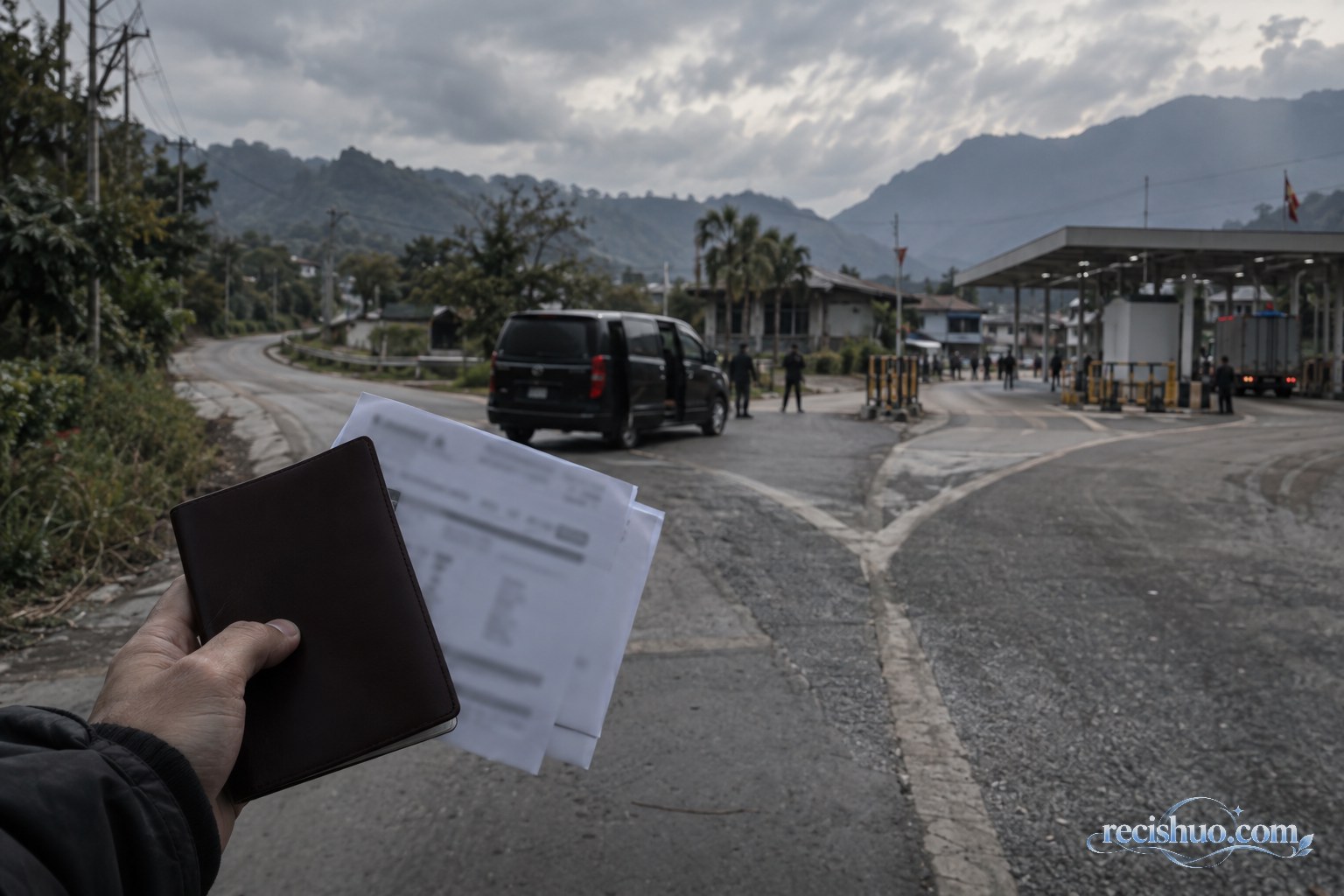 边境道路岔口前有人拿着证件套和模糊行程资料