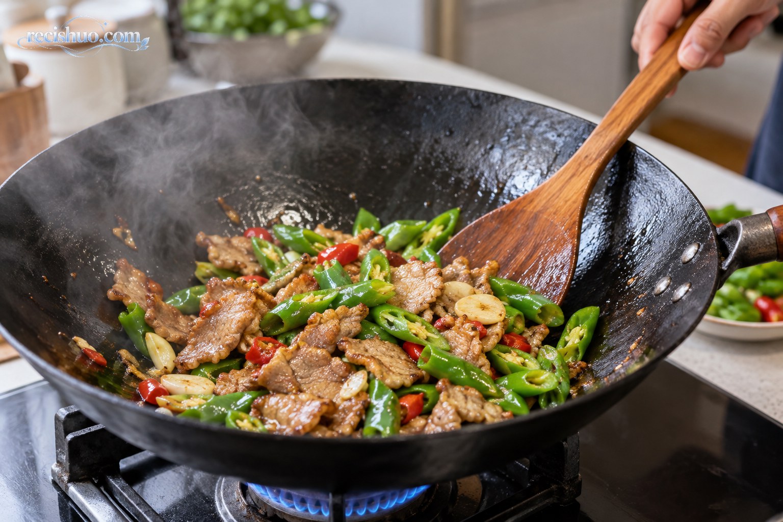 铁锅中正在翻炒的青椒肉片和蒜片