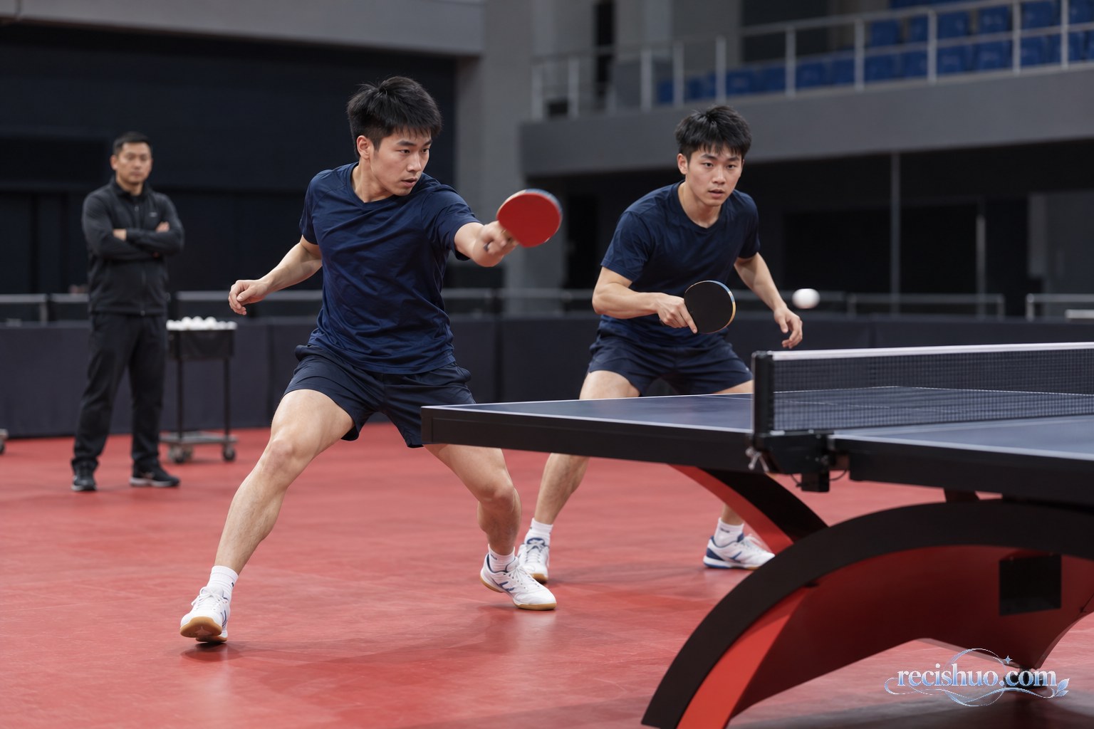 两名乒乓球运动员在训练馆进行男双轮转配合练习