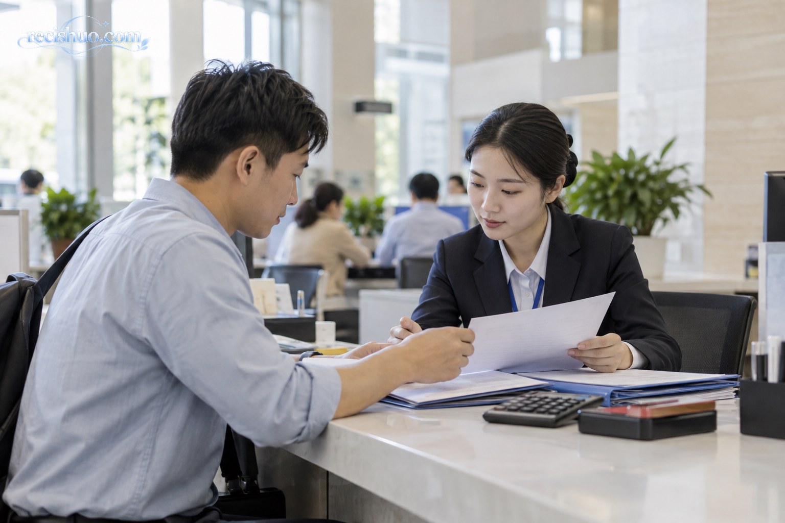 职工在公共服务窗口与工作人员核对社会保险办理材料