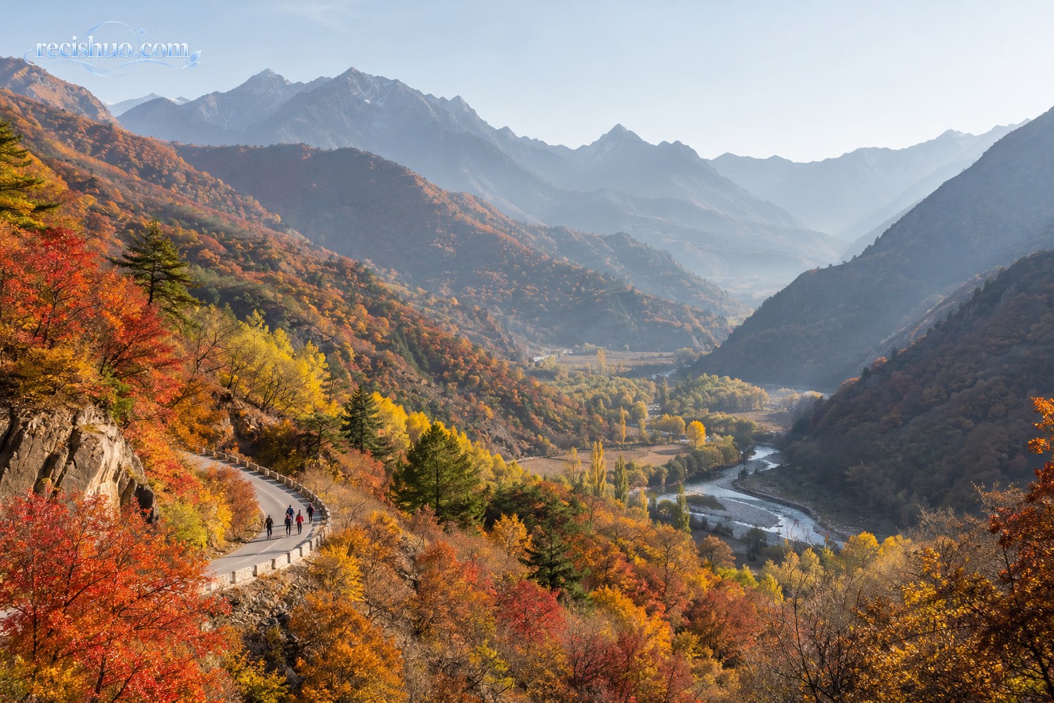 秋日山谷中红黄林木与远处冷色山脊形成季节层次
