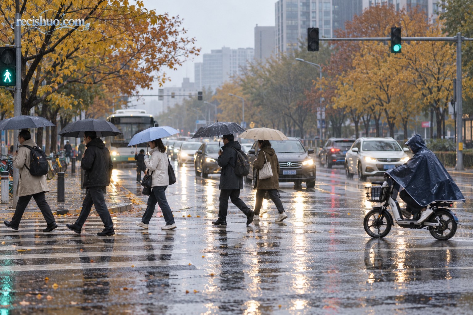 北京秋雨中的城市路口,行人撑伞过街、骑行者穿雨衣通行