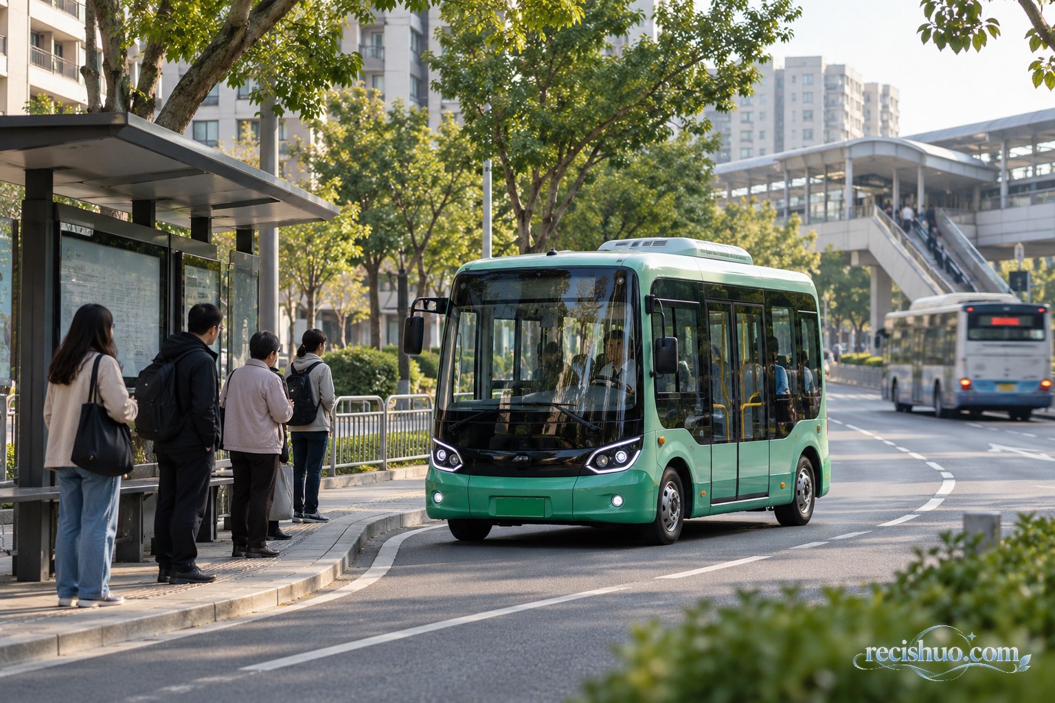 城市公交站旁，小型社区公交进站，远处传统大型公交驶过