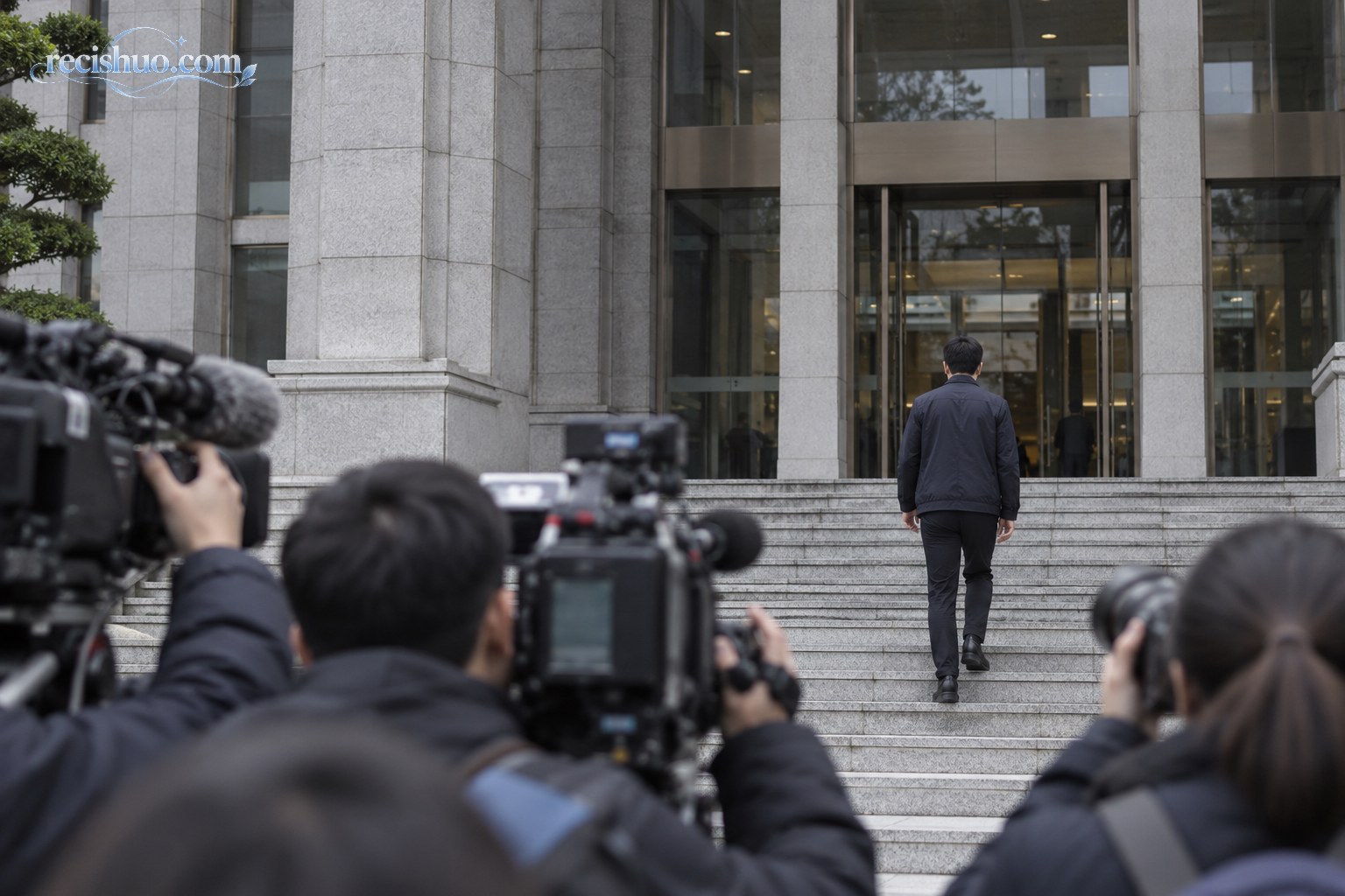 一名无法识别身份的男子在媒体镜头前走向现代法院入口