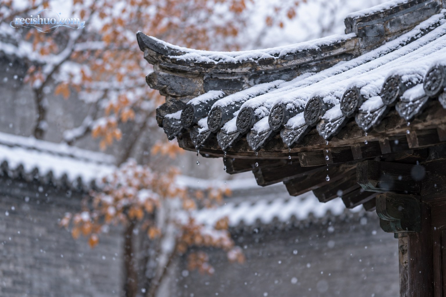 薄雪覆盖传统建筑青灰瓦檐并逐渐融化滴水